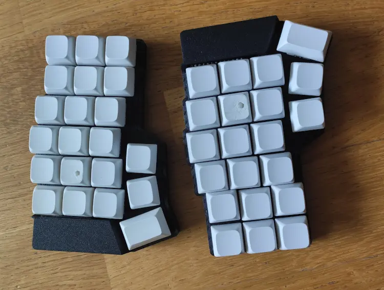 Two assembled Corney halves with white MX keycaps viewed from above.